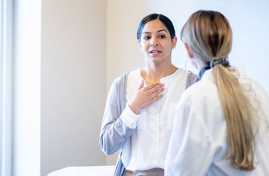 Patient in an exam room talking to a doctor.